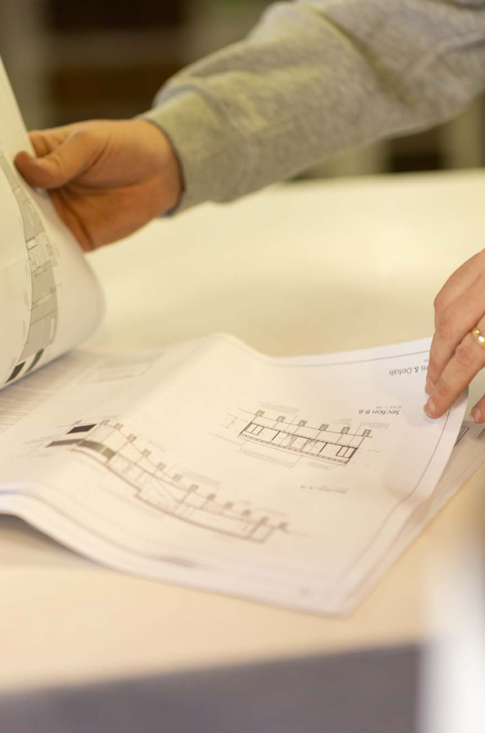 close up of hands holding plans on paper