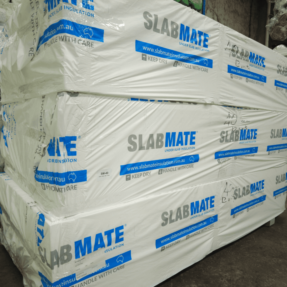 Stack of SLAB MATE insulation in packaging on pallets with branding and care instructions.